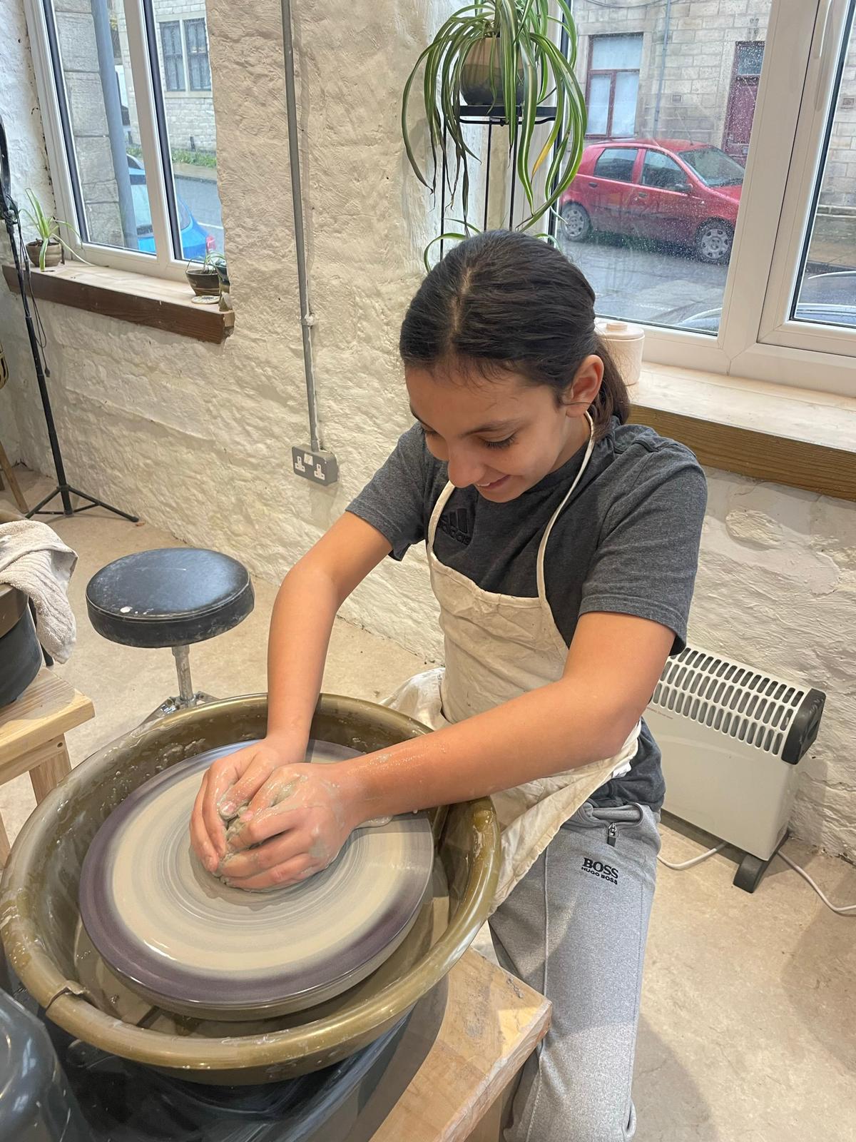 Student enjoying this time on the pottery wheel
