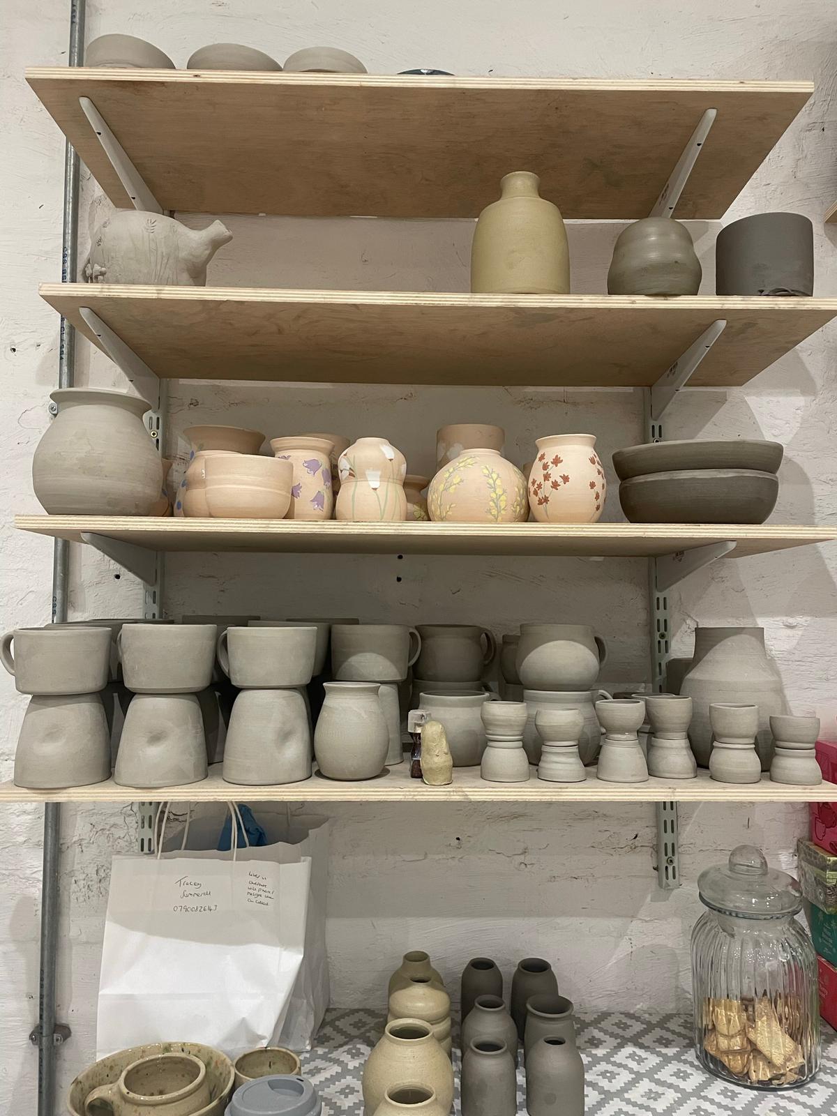 Shelves full of pottery from pottery wheel class