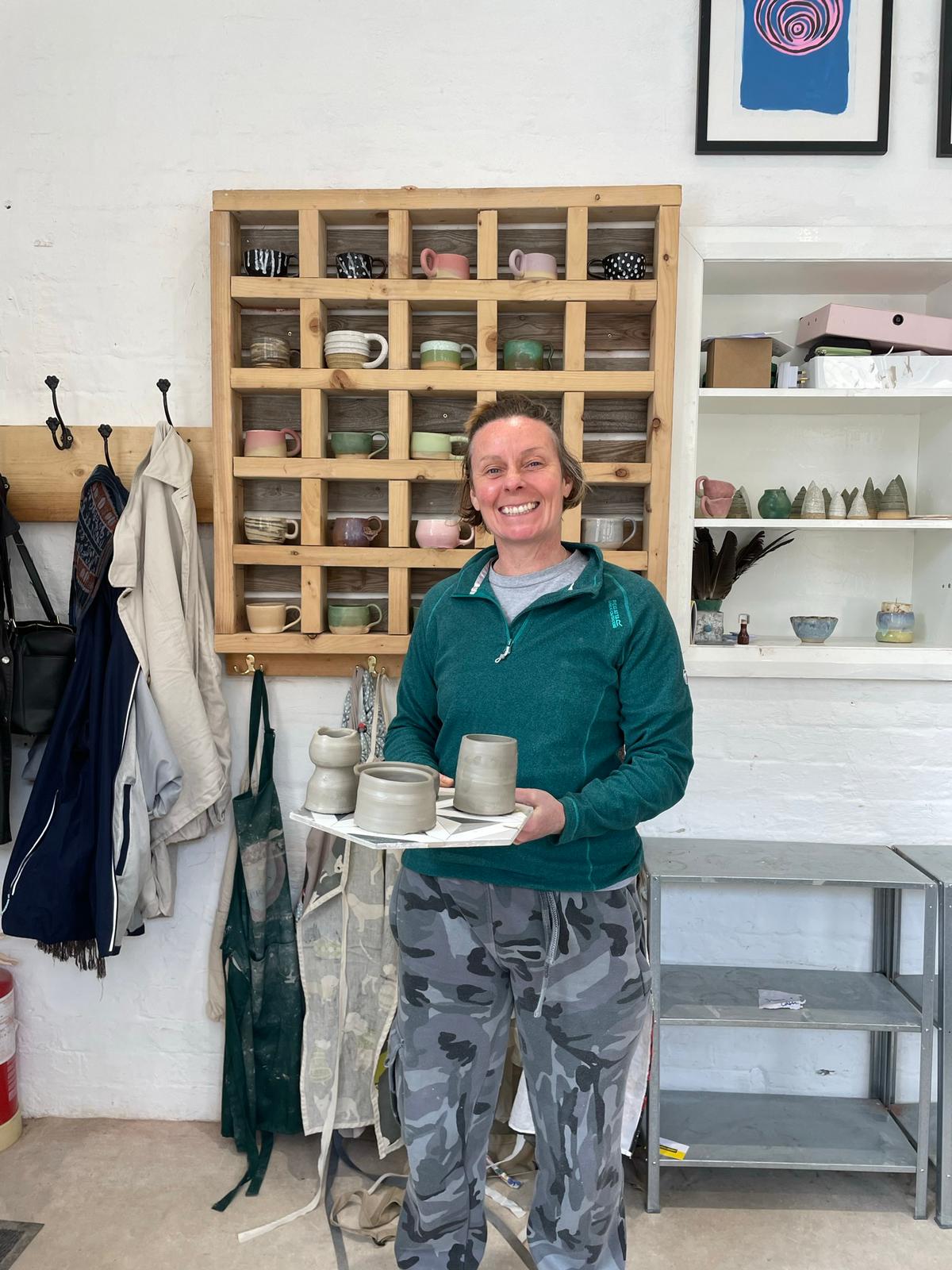 Student with her ceramic pieces made on the wheel